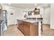 Bright kitchen featuring an island, granite countertops, stainless steel dishwasher, and wood-style tile flooring at 21667 S 225Th Way, Queen Creek, AZ 85142