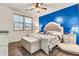 Bedroom with blue accent wall, natural light, and wood-look flooring at 21667 S 225Th Way, Queen Creek, AZ 85142