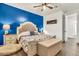 Cozy primary bedroom featuring a blue accent wall, ceiling fan, and stylish furniture at 21667 S 225Th Way, Queen Creek, AZ 85142