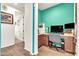 Bright office space featuring a desk, storage cabinets, and teal accent wall at 21667 S 225Th Way, Queen Creek, AZ 85142
