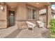 Inviting covered front porch featuring chairs and a side table to enjoy your morning coffee at 21667 S 225Th Way, Queen Creek, AZ 85142