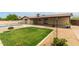 An expansive backyard with a pool, covered patio, lush lawn, and low maintenance landscaping at 2210 W Tonto Ln, Phoenix, AZ 85027