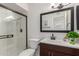 Modern bathroom featuring glass-enclosed shower, dark vanity, and contemporary mirror at 2210 W Tonto Ln, Phoenix, AZ 85027
