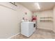 Well-equipped laundry room featuring a washer, dryer, and shelving for organized storage at 2210 W Tonto Ln, Phoenix, AZ 85027
