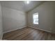 This bedroom features wood-look flooring, a bright window, and vaulted ceilings at 2233 E Behrend Dr # 203, Phoenix, AZ 85024