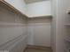 Walk-in closet featuring ample shelving and wooden racks providing optimal storage solutions at 2233 E Behrend Dr # 203, Phoenix, AZ 85024