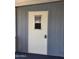 Exterior door on the home with a small window and metal siding around the trim at 2233 E Behrend Dr # 203, Phoenix, AZ 85024