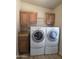 Well-organized laundry room with cabinets, granite countertop, and modern, front-loading washer and dryer at 2233 E Behrend Dr # 203, Phoenix, AZ 85024