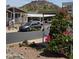 Neighborhood street view with a gray sedan parked under a carport and mountain views at 2233 E Behrend Dr # 203, Phoenix, AZ 85024