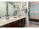 Bathroom features a double vanity with decorative framed artwork, adjacent to the shower at 27007 N 20Th Ln, Phoenix, AZ 85085