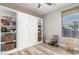 Charming bedroom featuring a Murphy bed, built-in shelves, a ceiling fan, and a sunny window at 27007 N 20Th Ln, Phoenix, AZ 85085