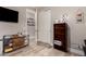 Bedroom with closet, desk, and tv with bright natural light and wood-look floors at 27007 N 20Th Ln, Phoenix, AZ 85085