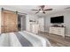 Bright bedroom features a sliding barn door to the bathroom, a ceiling fan, and neutral decor at 27007 N 20Th Ln, Phoenix, AZ 85085