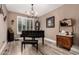 Formal dining room featuring a wood floor, a piano, an ornate chandelier, and a large window at 27007 N 20Th Ln, Phoenix, AZ 85085