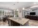 Bright open-concept kitchen with a large island, pendant lighting, and a seamless flow to the dining area at 27007 N 20Th Ln, Phoenix, AZ 85085
