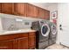 Well-equipped laundry room with ample cabinet space, a sink, and modern washer and dryer at 27007 N 20Th Ln, Phoenix, AZ 85085