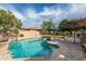 Inviting backyard pool with waterfall feature, lounge chairs, and lush landscaping, perfect for relaxing and entertaining at 27007 N 20Th Ln, Phoenix, AZ 85085