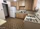 Functional kitchen layout with standard appliances, ample cabinetry and flooring in need of updating at 2937 W Marshall Ave, Phoenix, AZ 85017