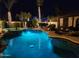 Sparkling backyard pool and spa with a waterfall feature, surrounded by lush landscaping and soft lighting at 2991 E Fandango Dr, Gilbert, AZ 85298