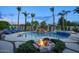 Tranquil pool with a fire pit, waterfalls, and tall palm trees, creating a perfect backyard oasis at 2991 E Fandango Dr, Gilbert, AZ 85298