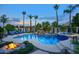 Inviting pool area with rock waterfall, spa, fire bowls, and palm trees creating a backyard oasis at 2991 E Fandango Dr, Gilbert, AZ 85298