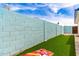 Spacious backyard featuring well-maintained turf and an eye-catching light blue cinder block wall at 3038 E Avalon Dr, Phoenix, AZ 85016