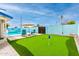 Lush backyard with a pristine putting green, swimming pool, lounge chairs and vibrant landscaping at 3038 E Avalon Dr, Phoenix, AZ 85016