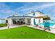 Expansive backyard featuring a putting green, pool with lounge chairs, a covered patio with seating, and lush greenery at 3038 E Avalon Dr, Phoenix, AZ 85016