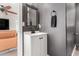 Cozy powder room with decorative light fixture, dark grey walls, white vanity, and towel rack at 3038 E Avalon Dr, Phoenix, AZ 85016