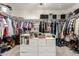 Walk-in closet with ample storage, including hanging rods, shelves, and a central storage unit at 3038 E Avalon Dr, Phoenix, AZ 85016