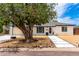 Charming single-story home featuring a tire swing, tidy desert landscaping, and white brick exterior at 3038 E Avalon Dr, Phoenix, AZ 85016