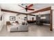 Open-concept living room with wood beams, a ceiling fan, gray walls, and views of the dining and kitchen area at 3038 E Avalon Dr, Phoenix, AZ 85016