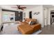 Spacious living room with designer leather couch, modern ceiling fan, neutral rug, and light grey flooring at 3038 E Avalon Dr, Phoenix, AZ 85016