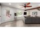 Bright living room featuring a ceiling fan, tiled floor, white walls, a door to the front yard, and a comfortable sofa at 3038 E Avalon Dr, Phoenix, AZ 85016