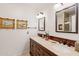 Elegant bathroom featuring a double vanity, stone countertops, and framed artwork at 31 W Marlette Ave, Phoenix, AZ 85013