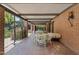Cozy covered patio with brick accents, outdoor seating, lush landscaping, and a tranquil backyard ambiance at 31 W Marlette Ave, Phoenix, AZ 85013