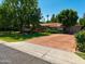 Home featuring a brick driveway leading to a two-car garage and a well-maintained garden at 31 W Marlette Ave, Phoenix, AZ 85013