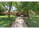 Landscaped front yard with mature trees, flowers, and a brick walkway leading to the home's entrance at 31 W Marlette Ave, Phoenix, AZ 85013