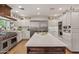 Spacious kitchen features stainless steel appliances, white cabinets, large island, and unique overhead decorations at 31 W Marlette Ave, Phoenix, AZ 85013