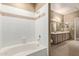 Bathroom with a tub and shower, with a double vanity with a light wood finish in the background at 3236 E Chandler Blvd # 2028, Phoenix, AZ 85048