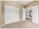 Bedroom with neutral carpet, bi-fold closet doors, and an open doorway into another room at 3236 E Chandler Blvd # 2028, Phoenix, AZ 85048