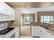 Kitchen with white cabinets and stainless steel sink, offering a view into a carpeted living area at 3236 E Chandler Blvd # 2028, Phoenix, AZ 85048
