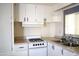 Kitchen showcasing white cabinets, gas stove, and sink, designed for efficient meal preparation and cleanup at 345 S 58Th St # 10, Mesa, AZ 85206