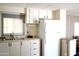Kitchen showcasing white cabinets, a refrigerator, and a sink under a window, maximizing space and functionality at 345 S 58Th St # 10, Mesa, AZ 85206