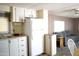 Kitchen with white cabinets and a refrigerator, with a view of the living area featuring a gray couch at 345 S 58Th St # 10, Mesa, AZ 85206