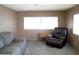 Living room featuring a gray couch and a leather recliner by a window, creating a comfortable and inviting space at 345 S 58Th St # 10, Mesa, AZ 85206