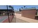 Fenced pickleball court surrounded by mature trees and community building at 345 S 58Th St # 10, Mesa, AZ 85206