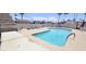 Scenic community pool with lounge chairs and tables for relaxation surrounded by lush palm trees and clear skies at 345 S 58Th St # 10, Mesa, AZ 85206