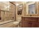 Bathroom featuring wood cabinets, a tiled shower with glass doors, and tile flooring at 35195 N 98Th St # 85, Scottsdale, AZ 85262