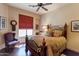 Comfortable bedroom features wood floors, ceiling fan, and a comfortable bed with pillows at 35195 N 98Th St # 85, Scottsdale, AZ 85262
